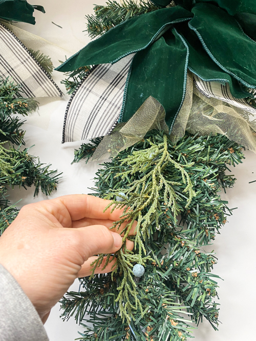 How to make DIY Dollar Store Christmas Swags for only $2.50 using supplies like 18" trees, floral wire, and ribbon. Perfect for budget-friendly holiday decor!