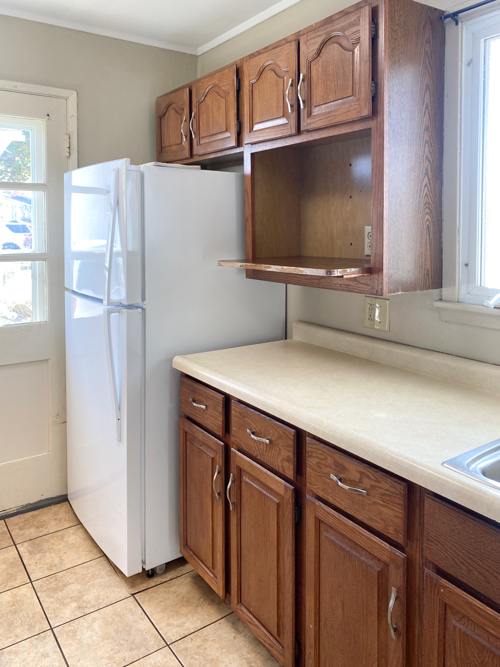 Learn how to freshen up kitchen cabinets without paint! Transform outdated cabinets with deep cleaning, stain + poly application for a budget-friendly makeover.