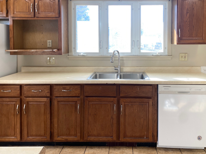 Learn how to freshen up kitchen cabinets without paint! Transform outdated cabinets with deep cleaning, stain + poly application for a budget-friendly makeover.