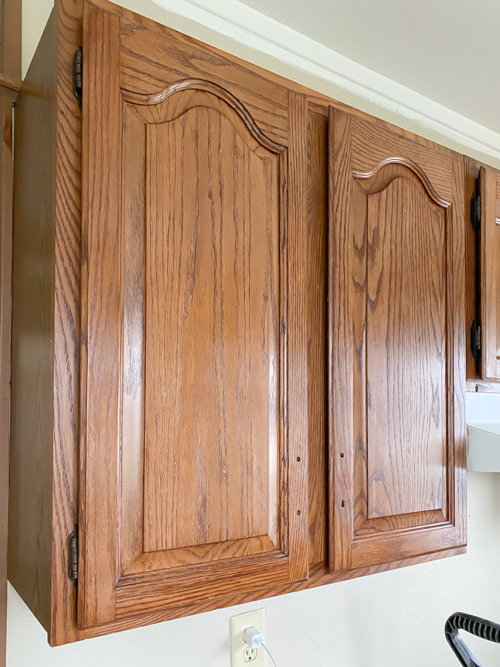 Learn how to freshen up kitchen cabinets without paint! Transform outdated cabinets with deep cleaning, stain + poly application for a budget-friendly makeover.